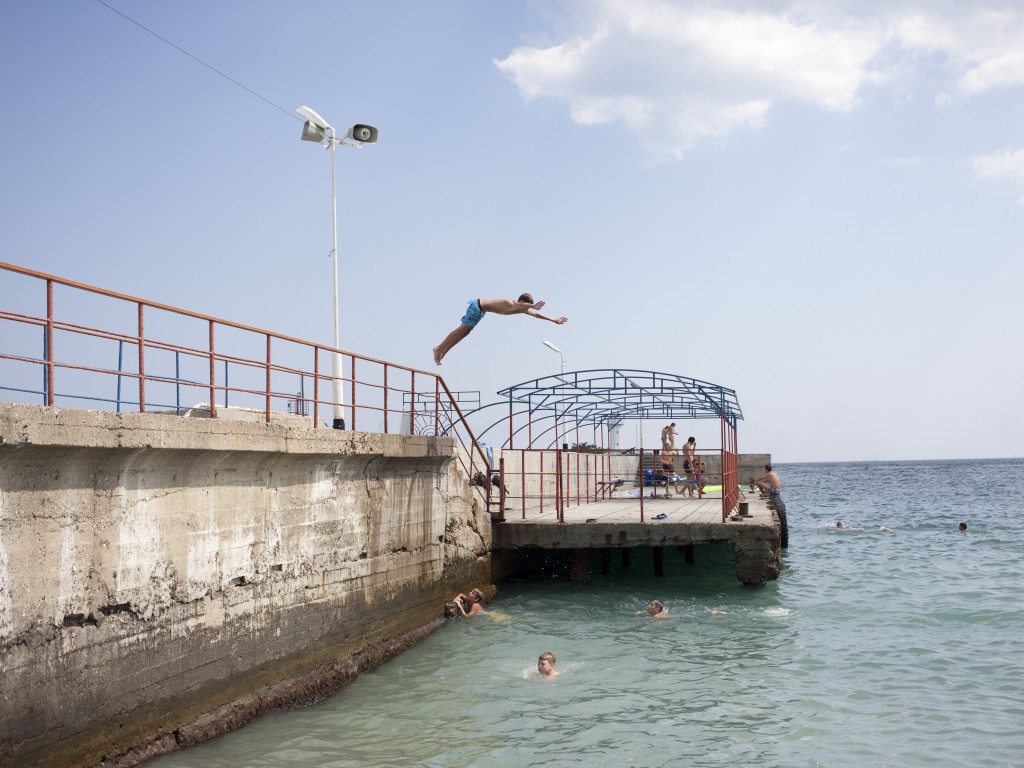 Boys are jumping into the Black Sea off the pier in Yalta Crimea. 05.08.14