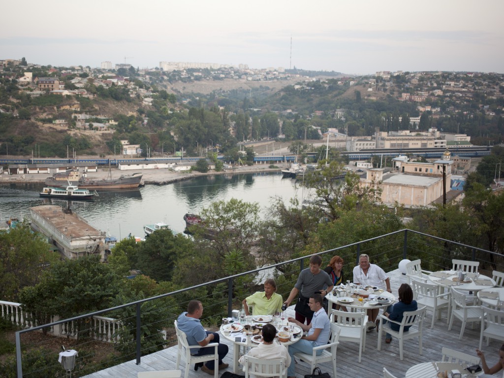People are enjoying dinner with a city view in Ostrov eco-cafe in Sevastopol. Crimea 06.08.14