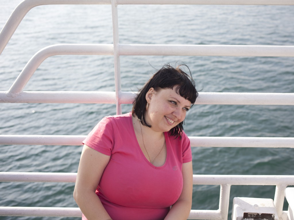 A woman from Novorossiysk having just arrived to Sevastopol with her friends for a vacation spends her time before hotel check-in on a ferry to the Northern side of Sevastopol Bay. Crimea 08.08.14